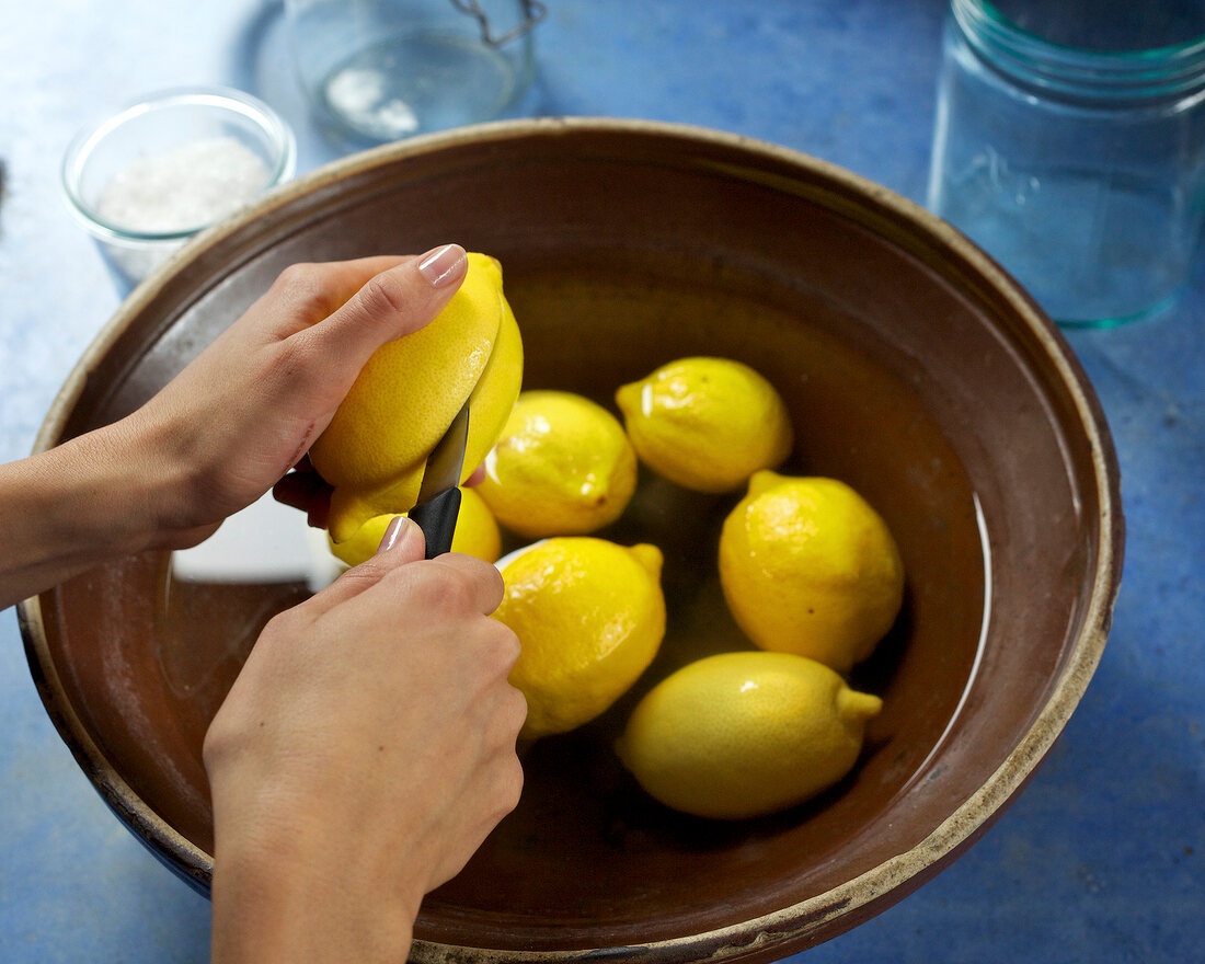 Close-up of hand cutting lemons