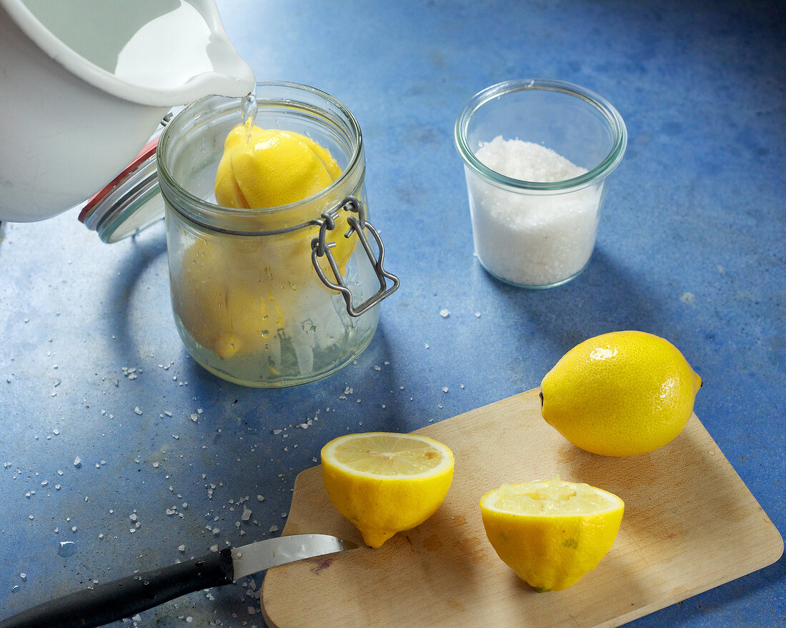 Boiling water being poured on lemon in jar