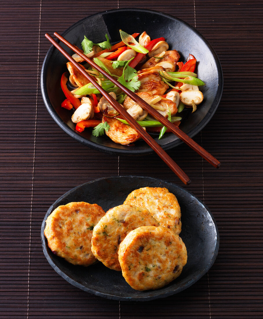 Two bowls of stir-fry chicken and chicken meatballs