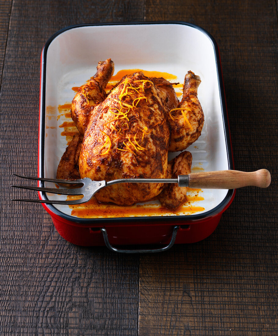 Roasted chicken with orange and coriander in casserole