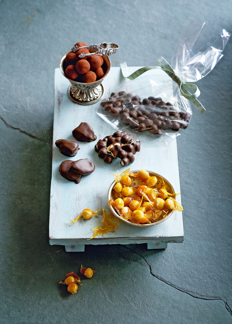 Various chocolates and nuts on wooden board