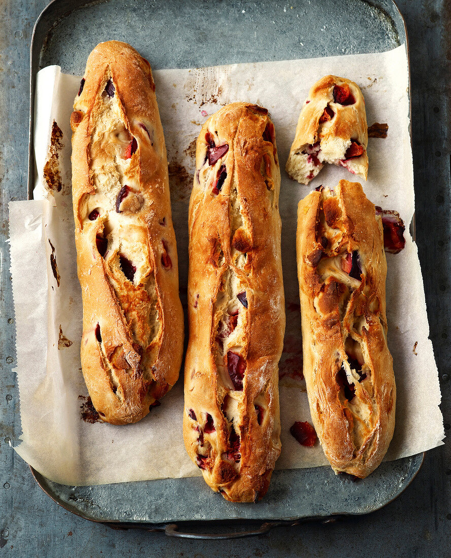 Brot, Pflaumenstangen mit Marzipan auf einem Backblech