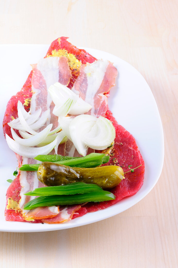 Flat meat with vegetables on plate for preparation of sauces and dips, step 2