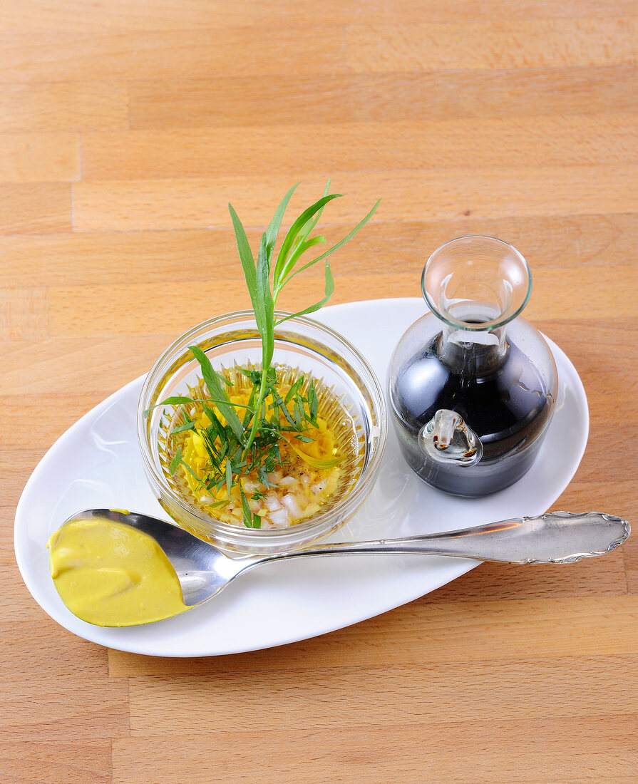 Ingredients of balsamic-tarragon vinaigrette on serving dish