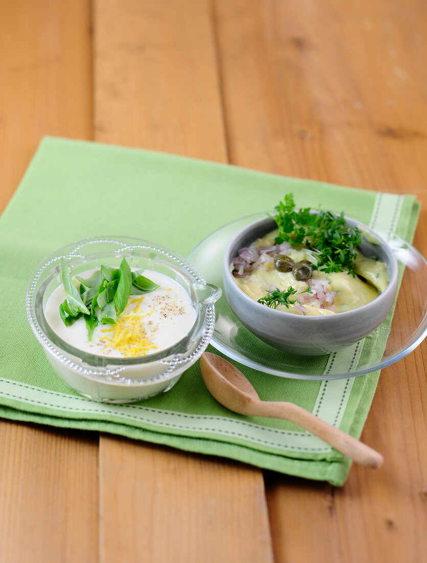 Mayonnaise in bowls on wooden napkin