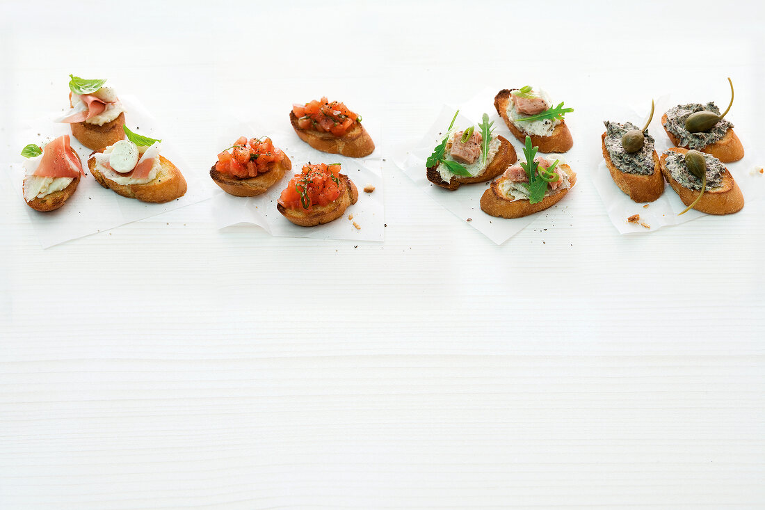 Four different type of crostini snacks on white background