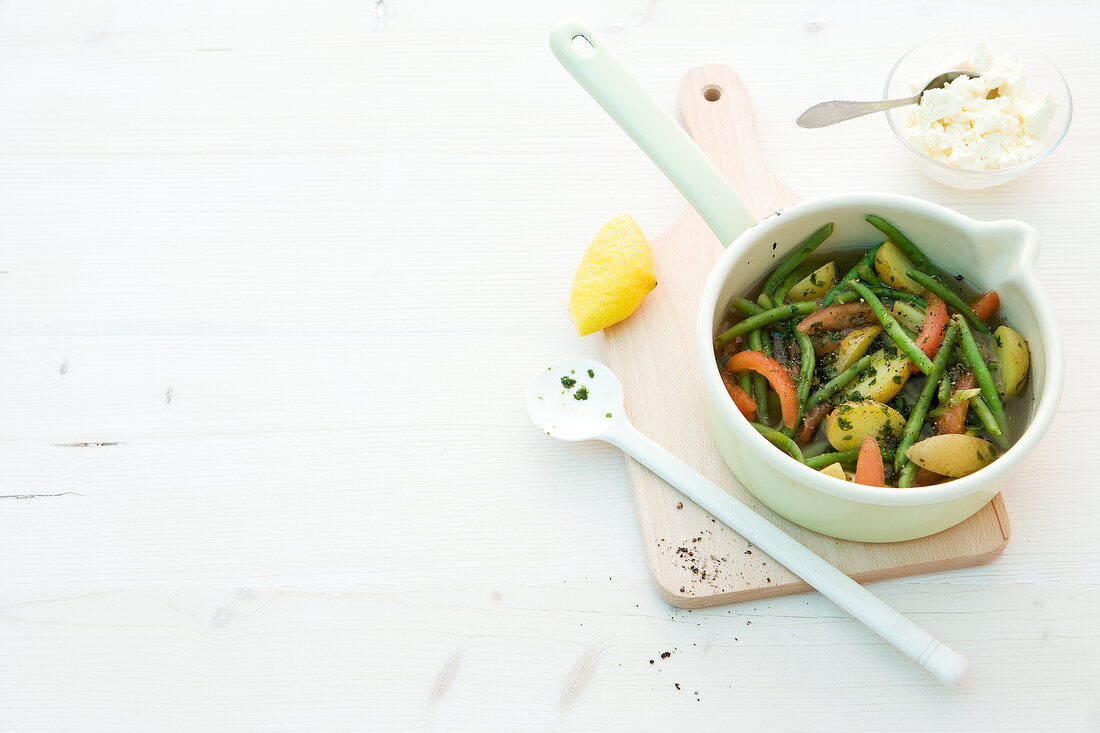 Green bean in pot on wooden chopping board