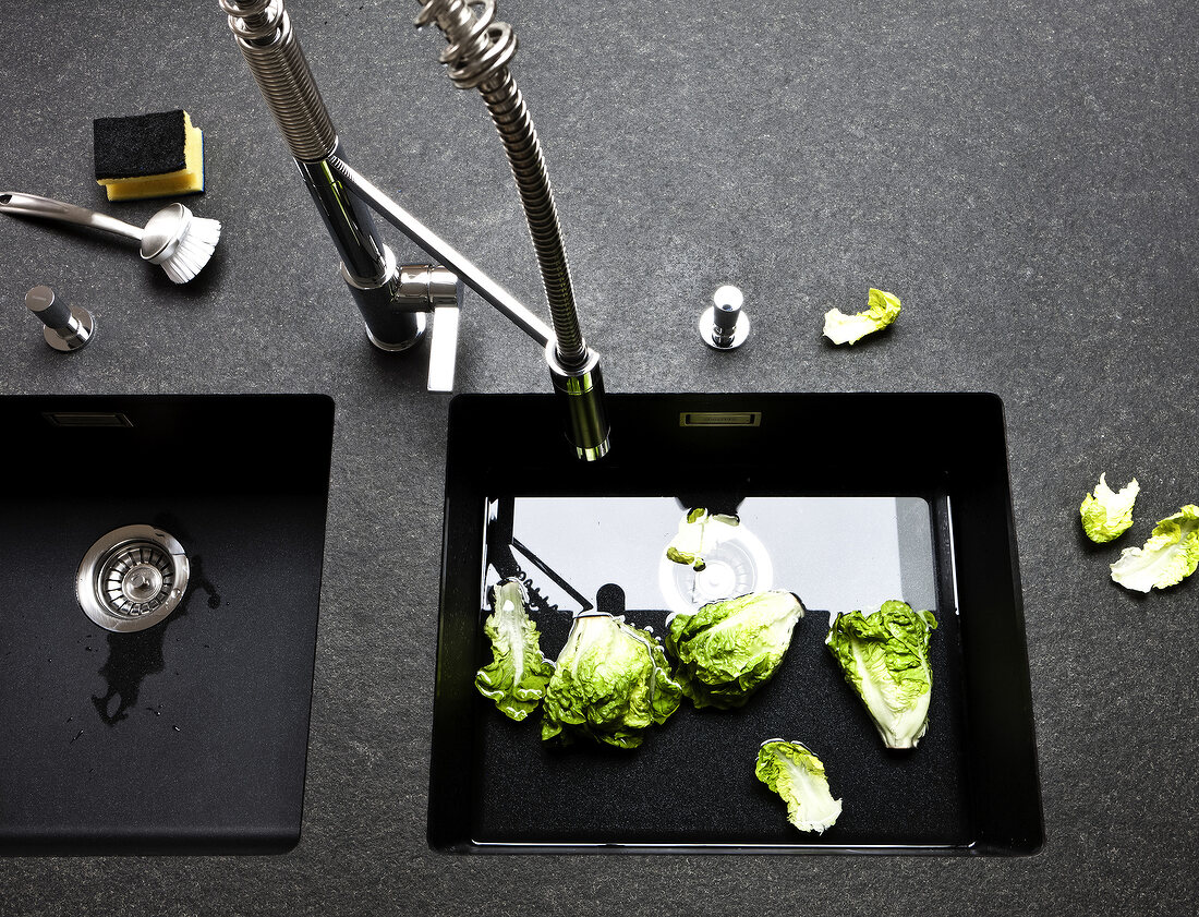 Romaine lettuce being washed in sink