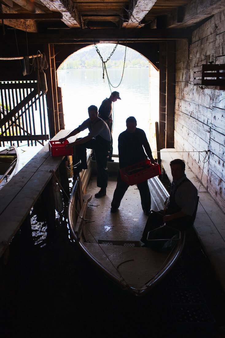 Männer von der Fischerei Tegernsee in einem Boot, Gegenlicht