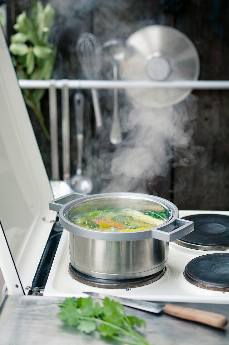 Vegetable broth on a stove outside