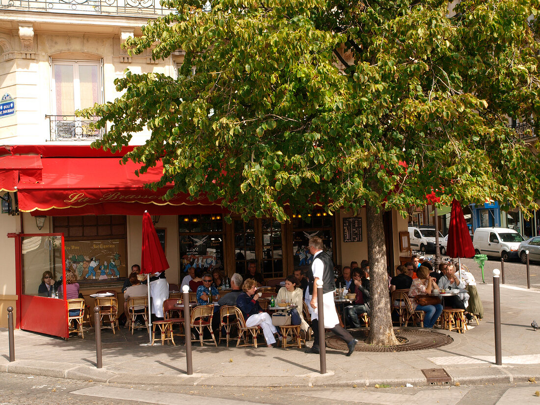 Guests sitting at tables outside Brasserie de L'Isle Saint-Louis in Paris, France