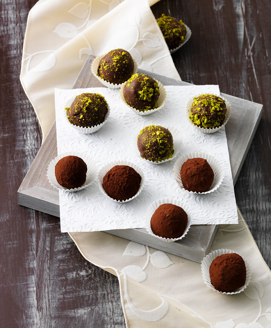 Chocolate truffles and marzipan sweets on white surface