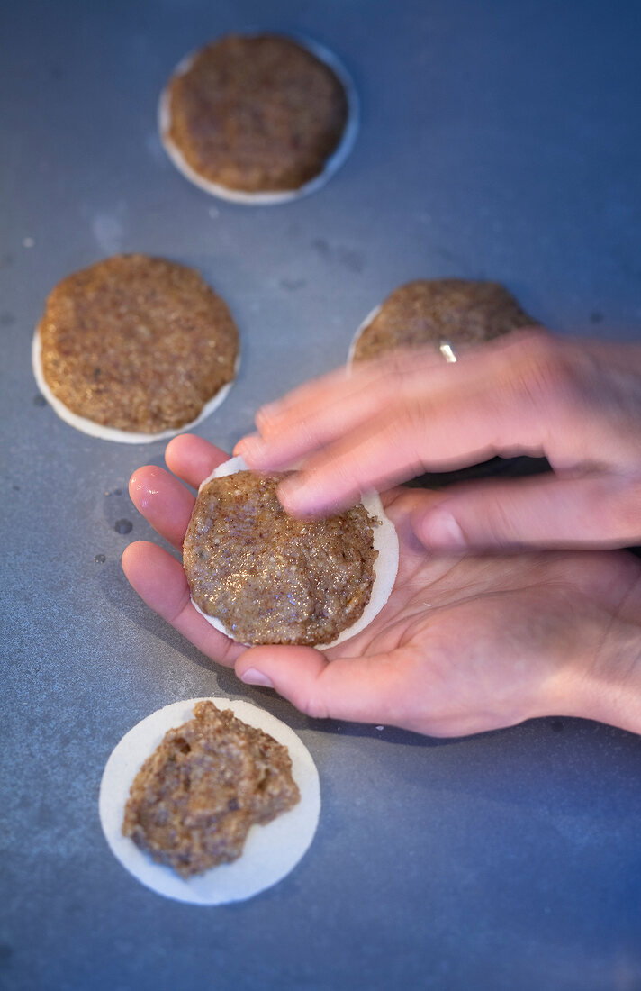 Close-up of dough being placed on wafers for preparation of Christmas cookies, step 2
