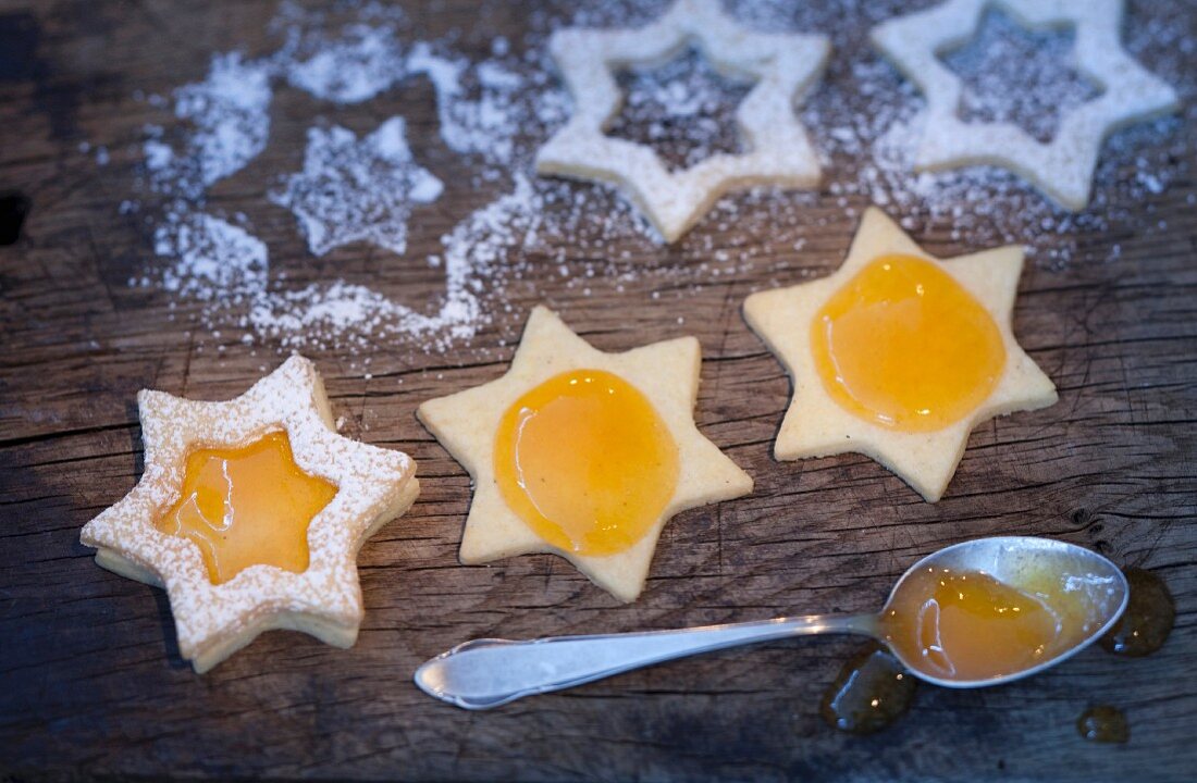 Star-shaped biscuits being spread with jam