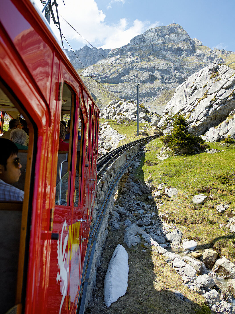 Passengers travelling in train between mountains at Alpnachstad, Lucerne, Switzerland