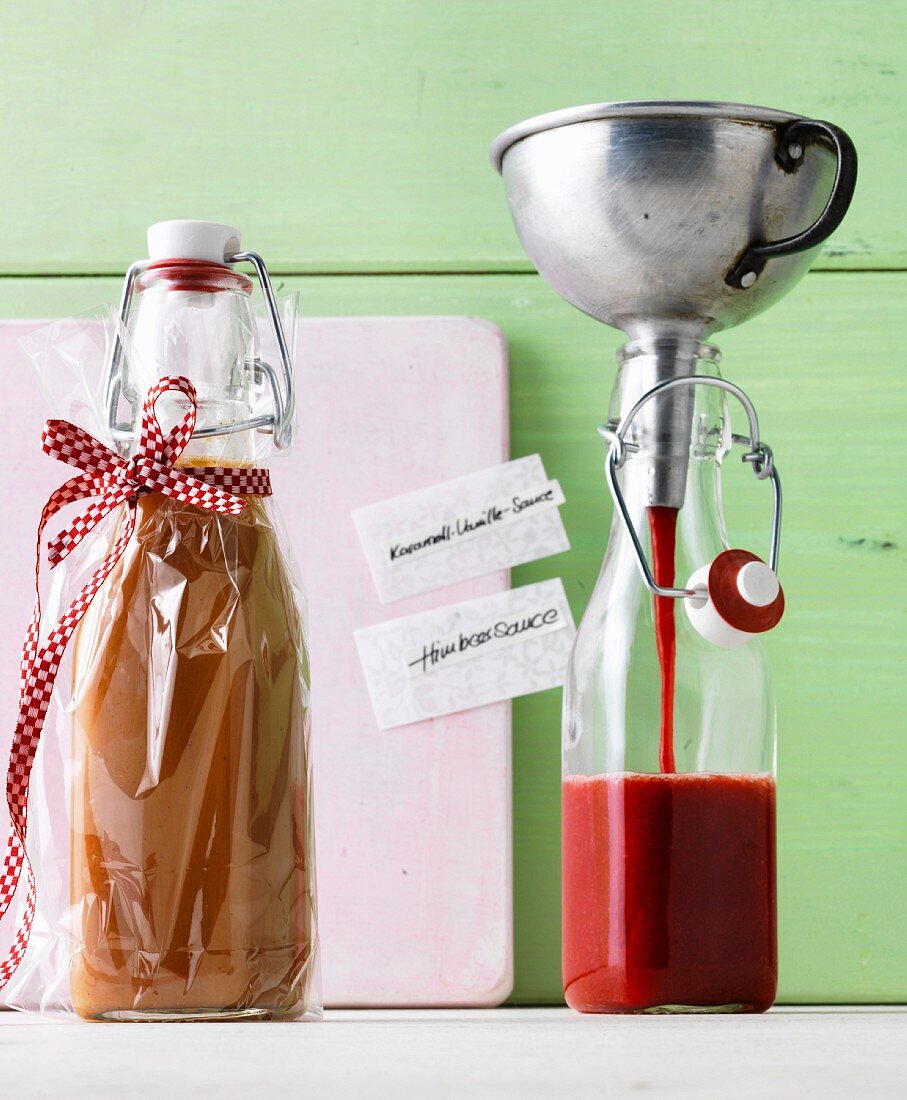 Homemade caramel-vanilla sauce and raspberry sauce in flip-top bottles