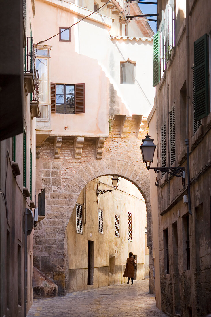 Woman walking in alley at the old town of Palma, Spain