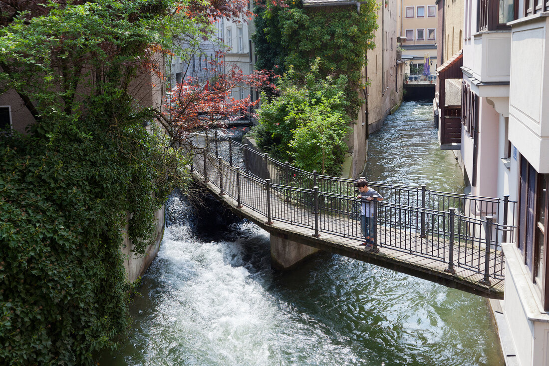 Boy standing on bridge in Augsburg, Bavaria, Germany