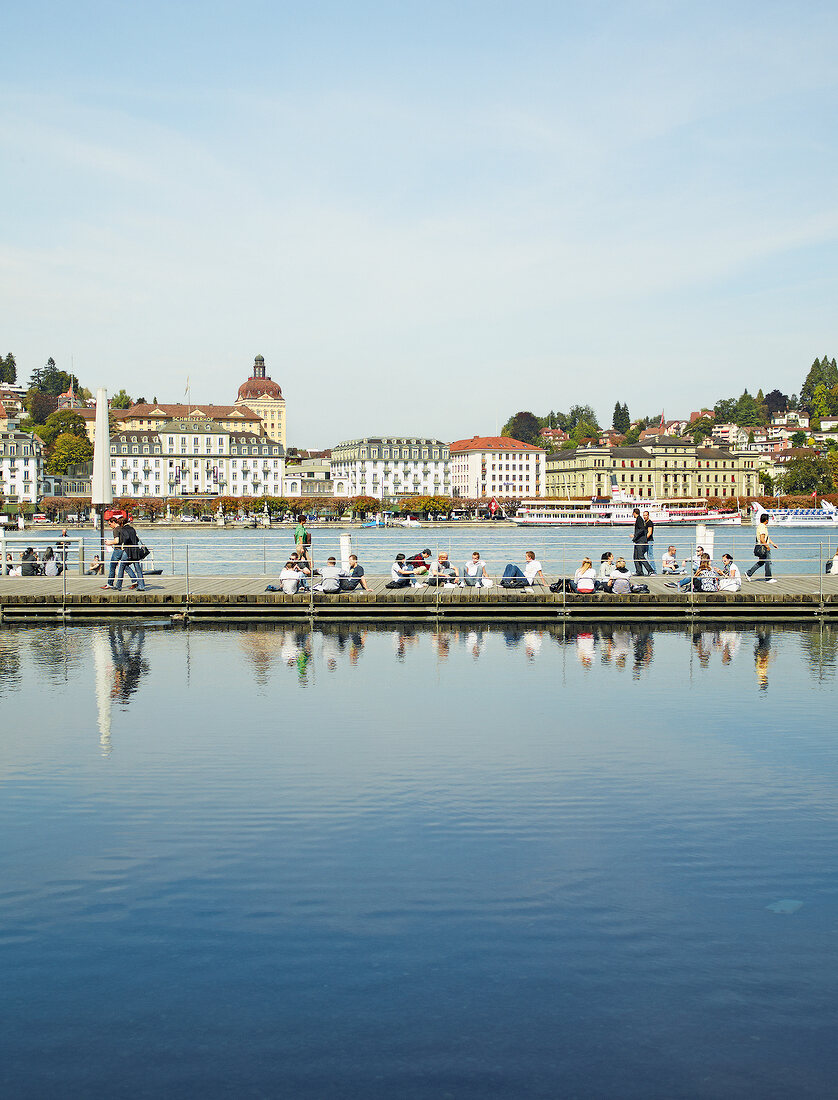 Cityscape of Lucerne and people sitting on jetty, Lake Lucerne, Switzerland