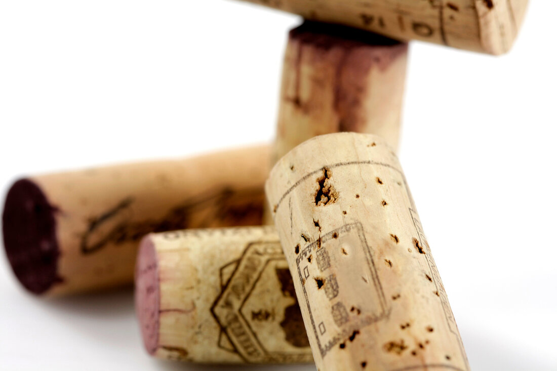 Close-up of five corks on white background