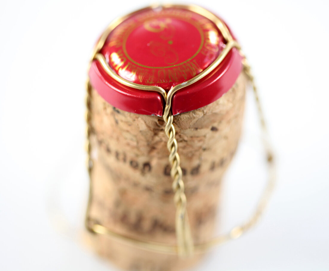 Close-up of champagne cork on white background