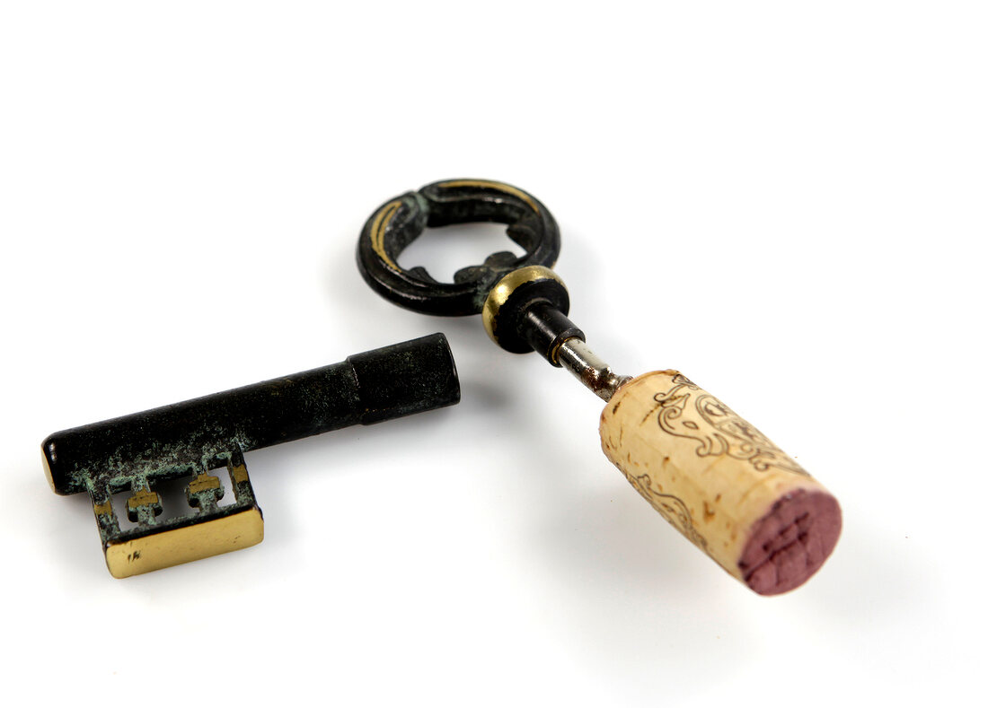 Wine cork with key shaped corkscrew on white background