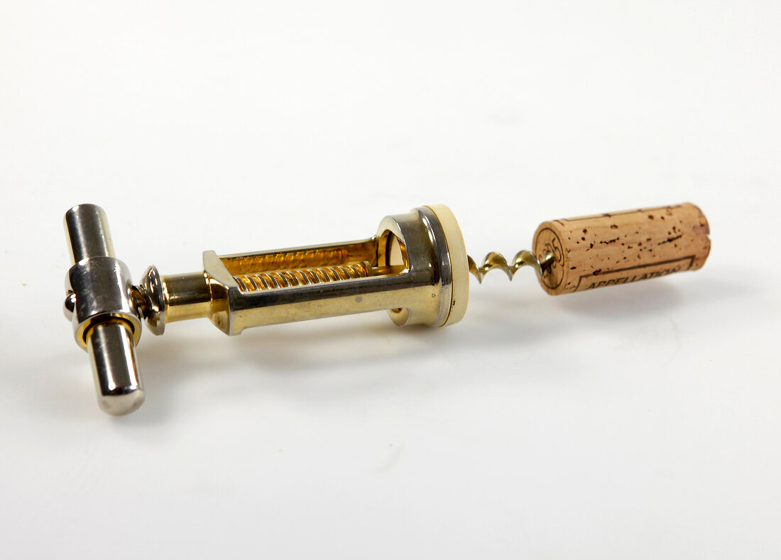 Cork with golden corkscrew on white background