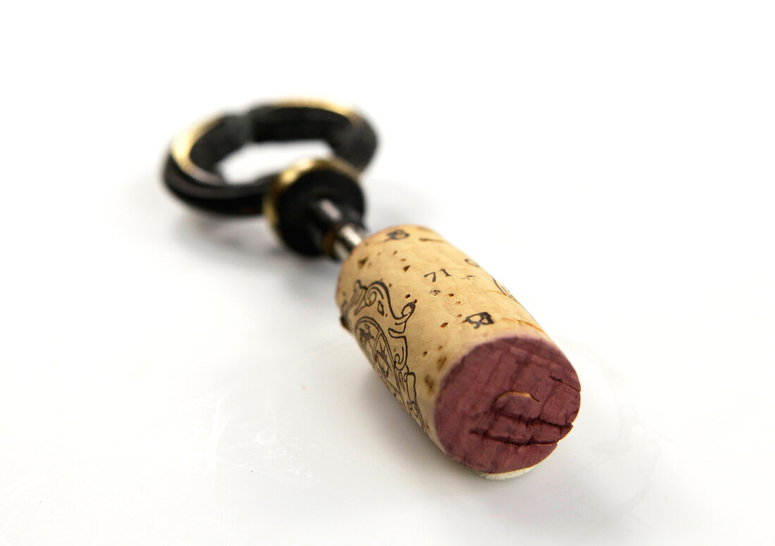 Wine cork with corkscrew on white background