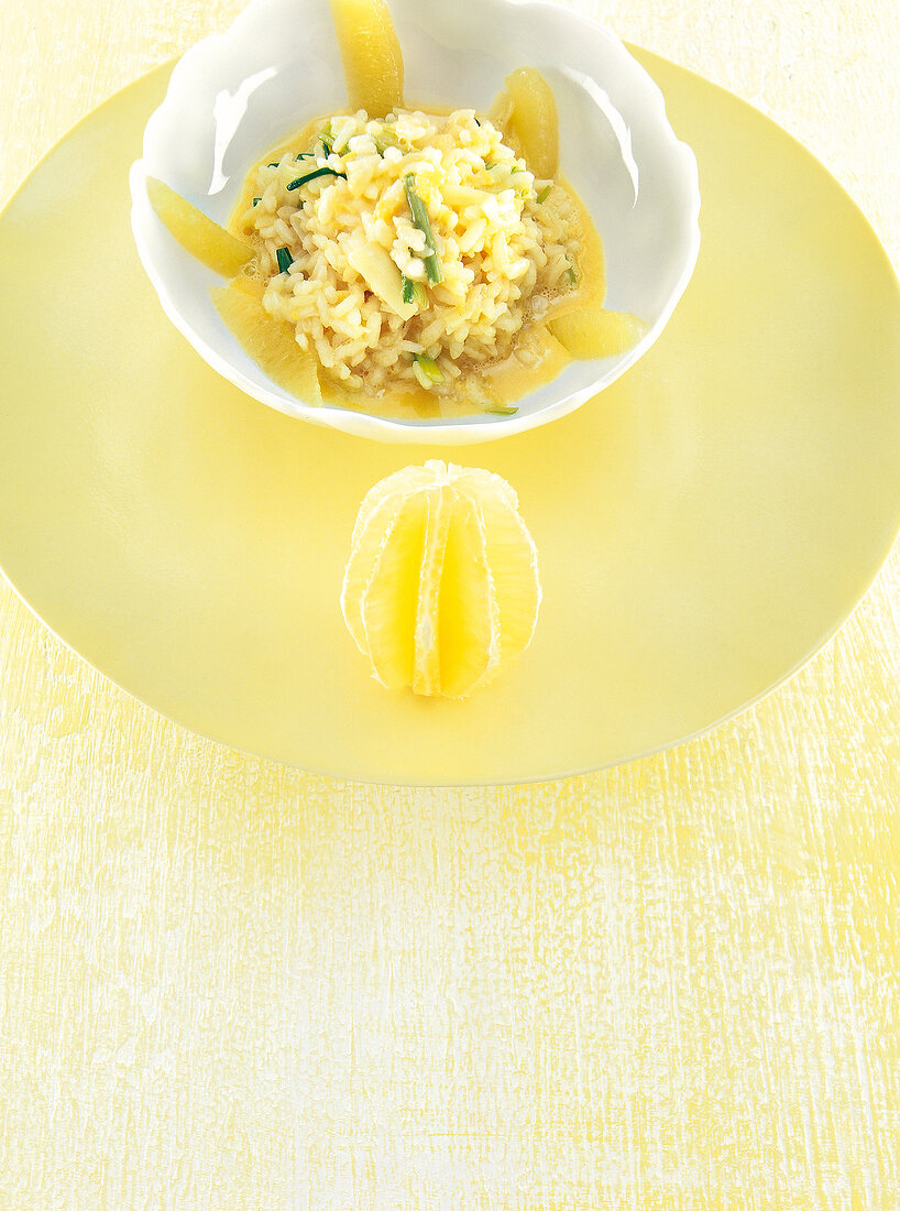 Bowl of lemon risotto and slice of lemon on plate