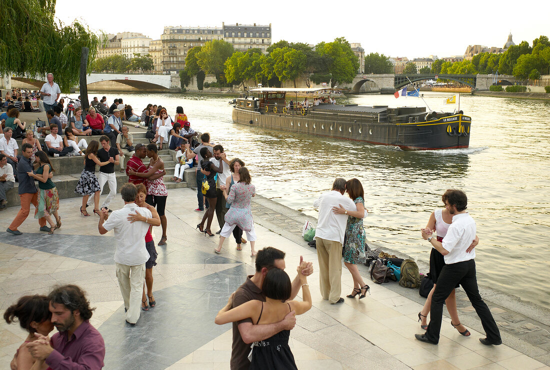 Couple dancing at the bank of Seine River in Paris, France