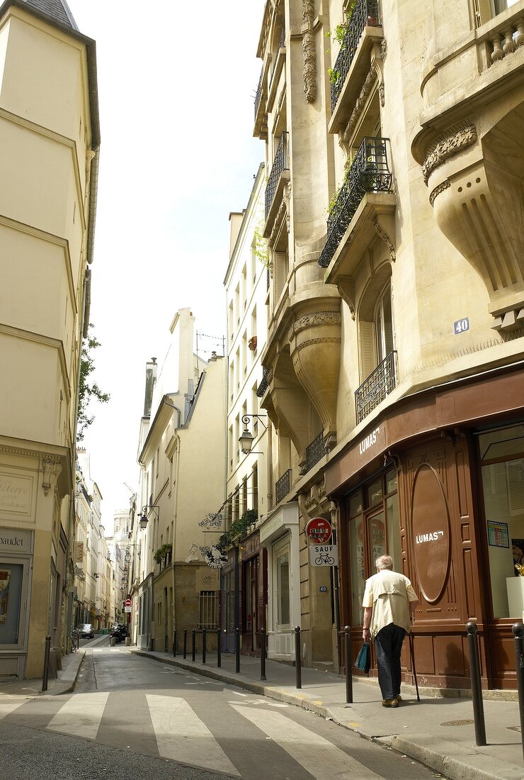 Man walking on sidewalk at Saint-Germain-des-Pres road in Paris, France