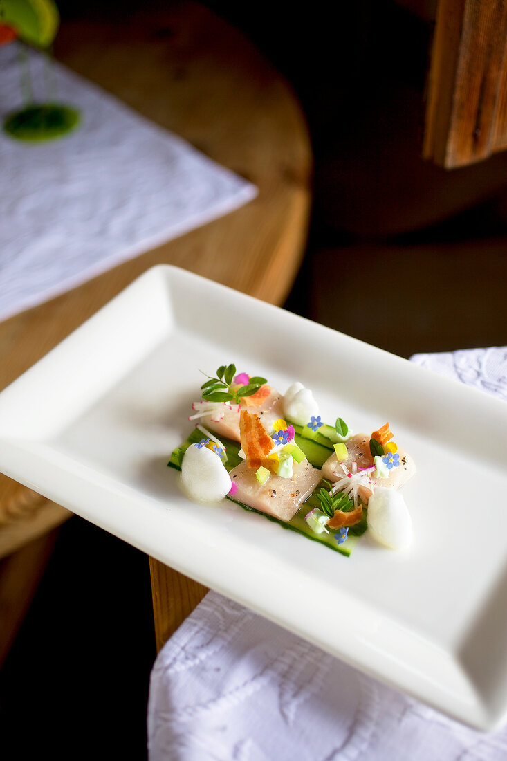 Arctic char with cucumber and flowers in serving dish
