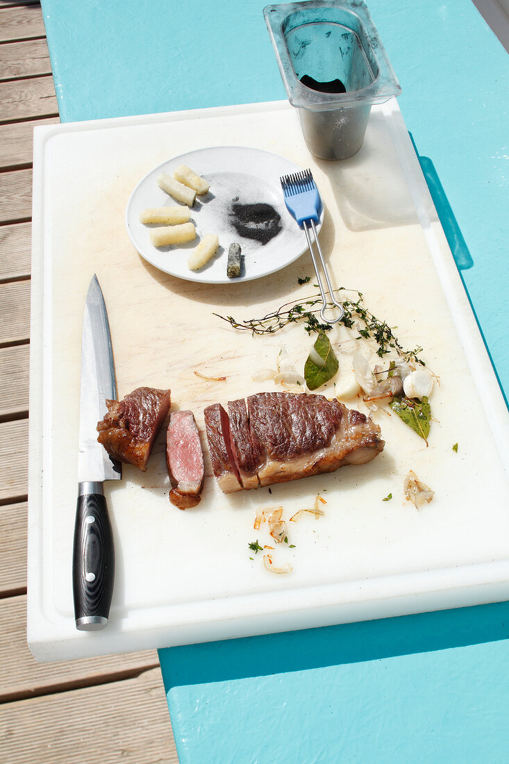 Wagyu sirloin being cut with knife on chopping board