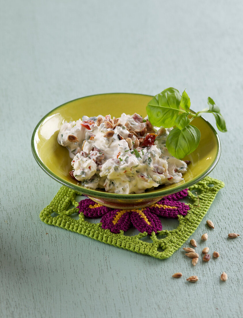 Herb cream cheese in bowl on mat