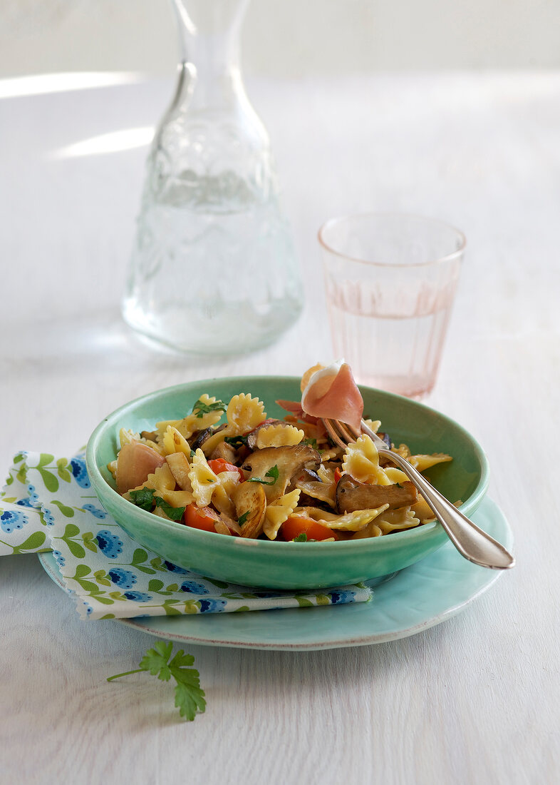 Farfalle with mushrooms in cream in serving dish