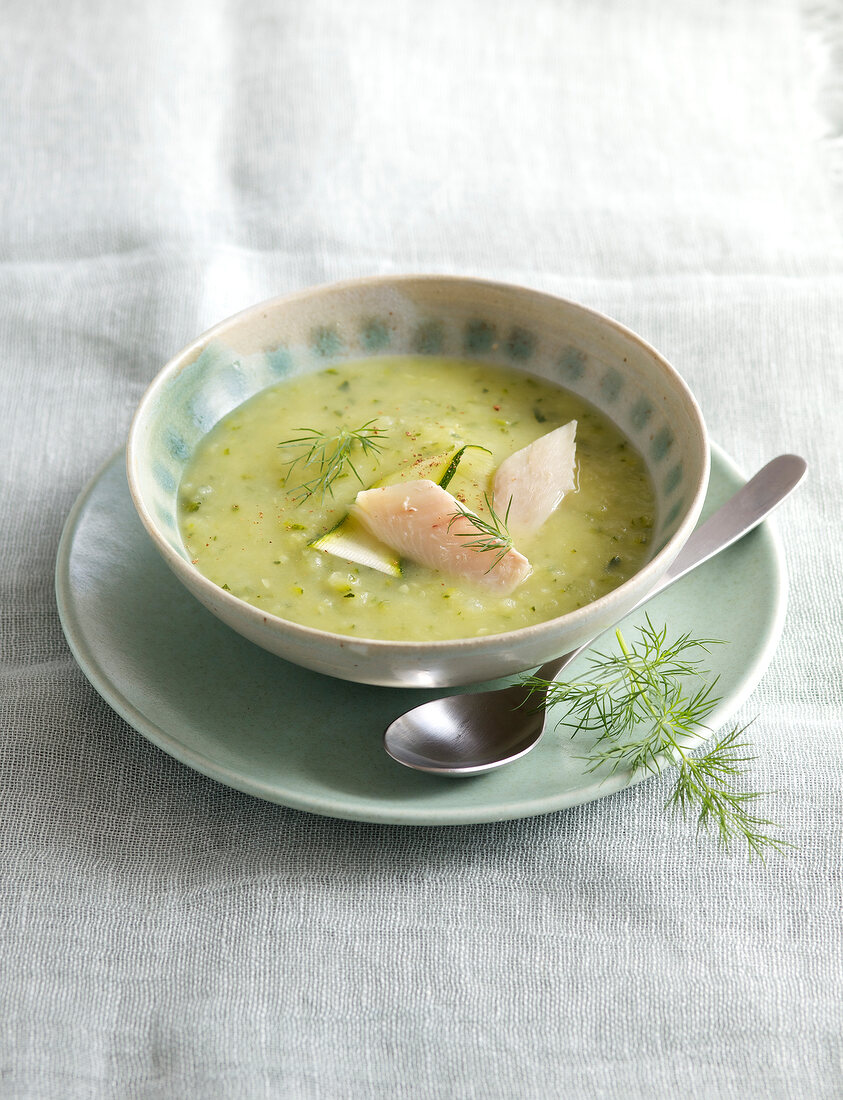 Cream of zucchini soup with trout in bowl