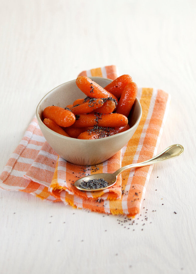 Bunch of carrots with poppy seed butter in bowl