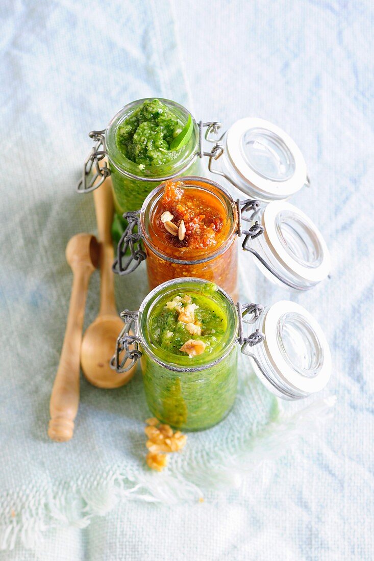 Basil pesto, tomato pesto and walnut pesto in flip-top jars