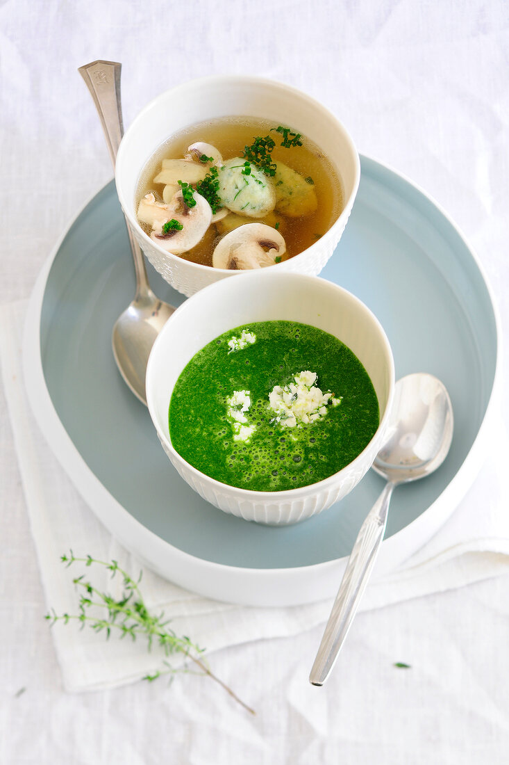 Bowls of spinach soup with feta gremolata and bouillon with Kaseklossc, low GI diet food