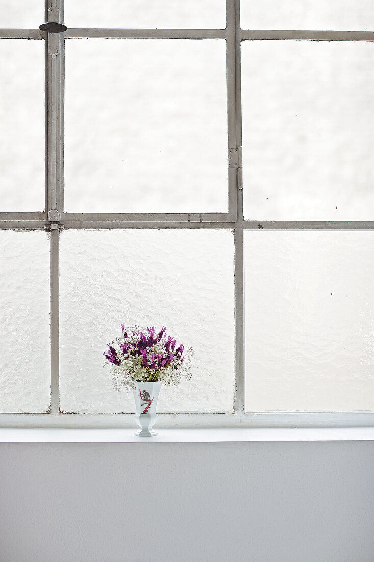 Vase with flowers on window sill