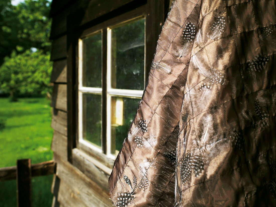 Close-up of brown fabric hanging next to window