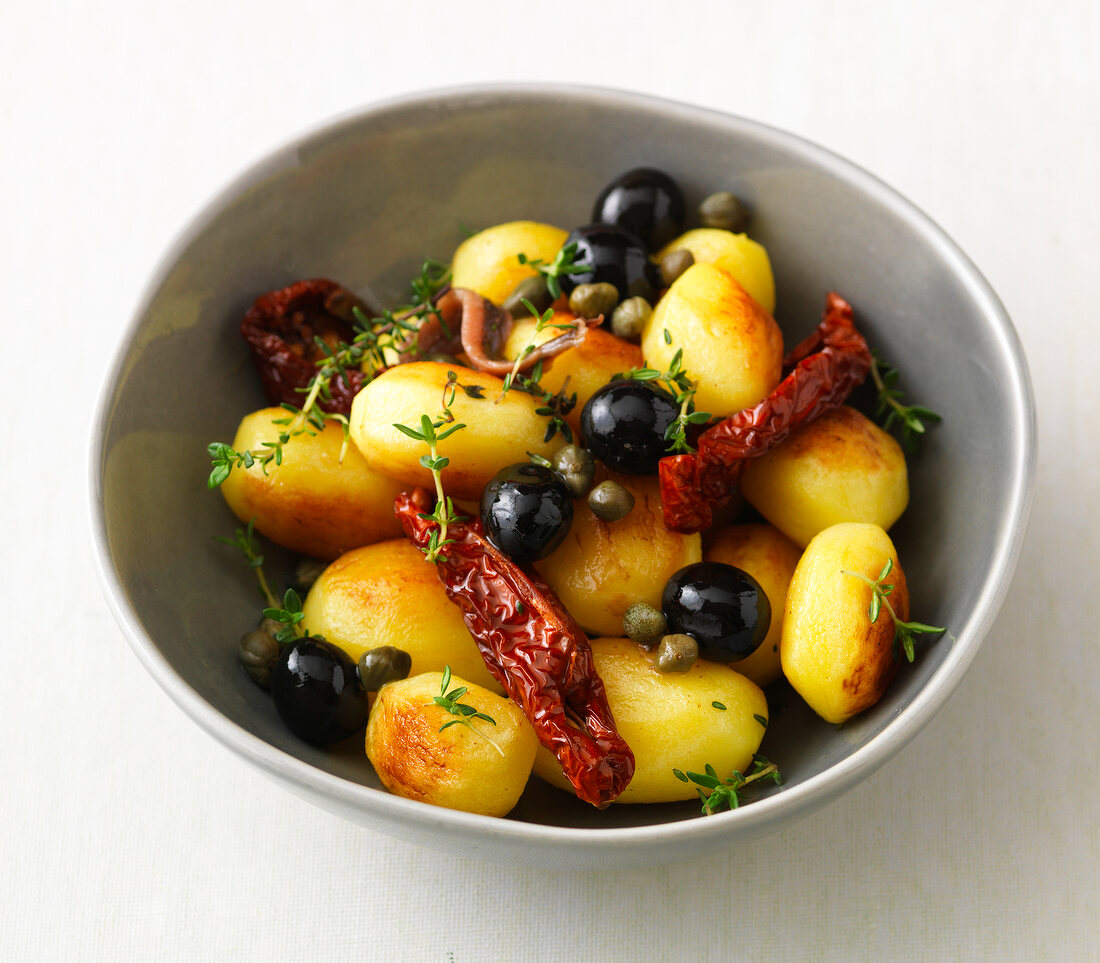 Potatoes with red chilli and black grapes in bowl