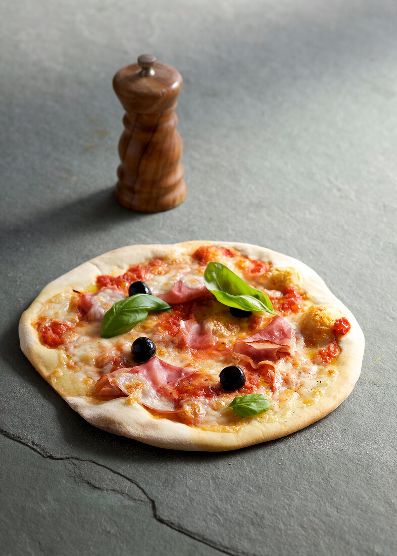 Pizza with ham on gray surface