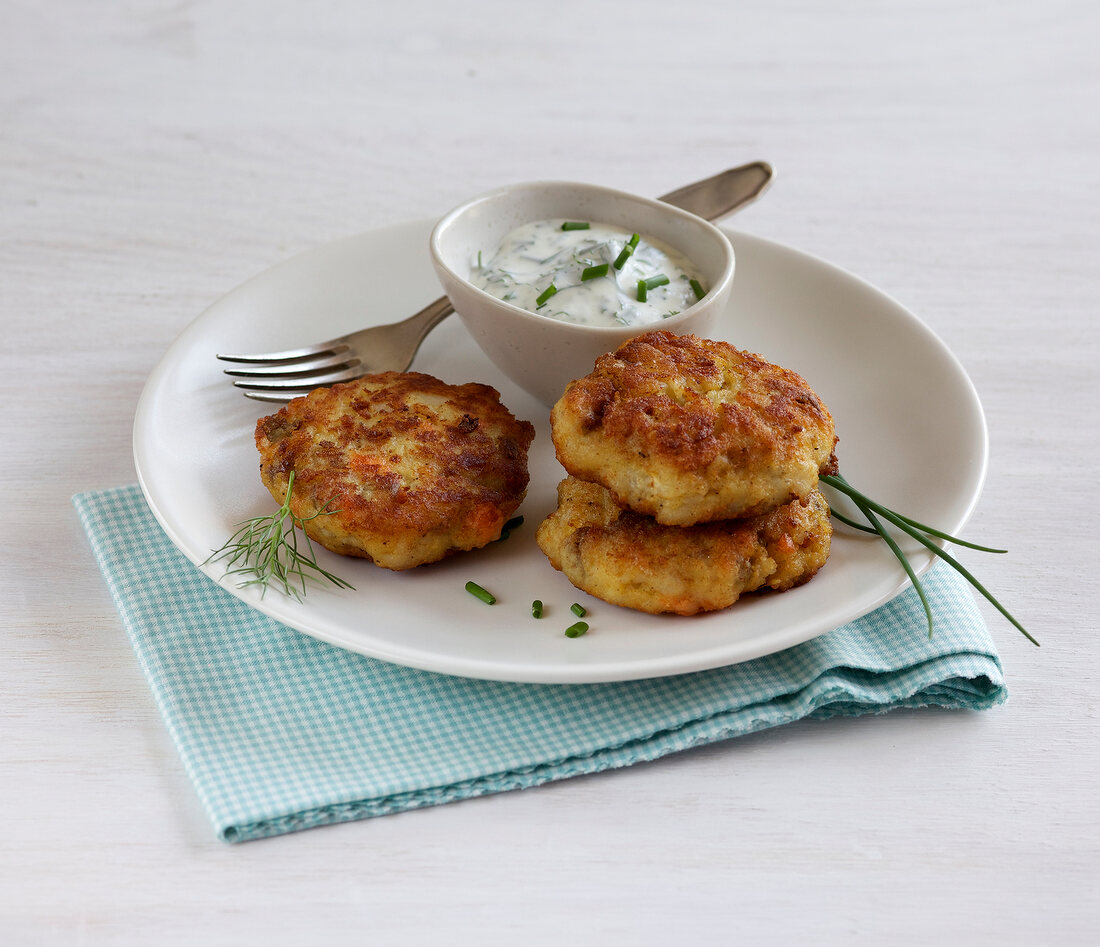 Fish cutlets with herb dip on plate