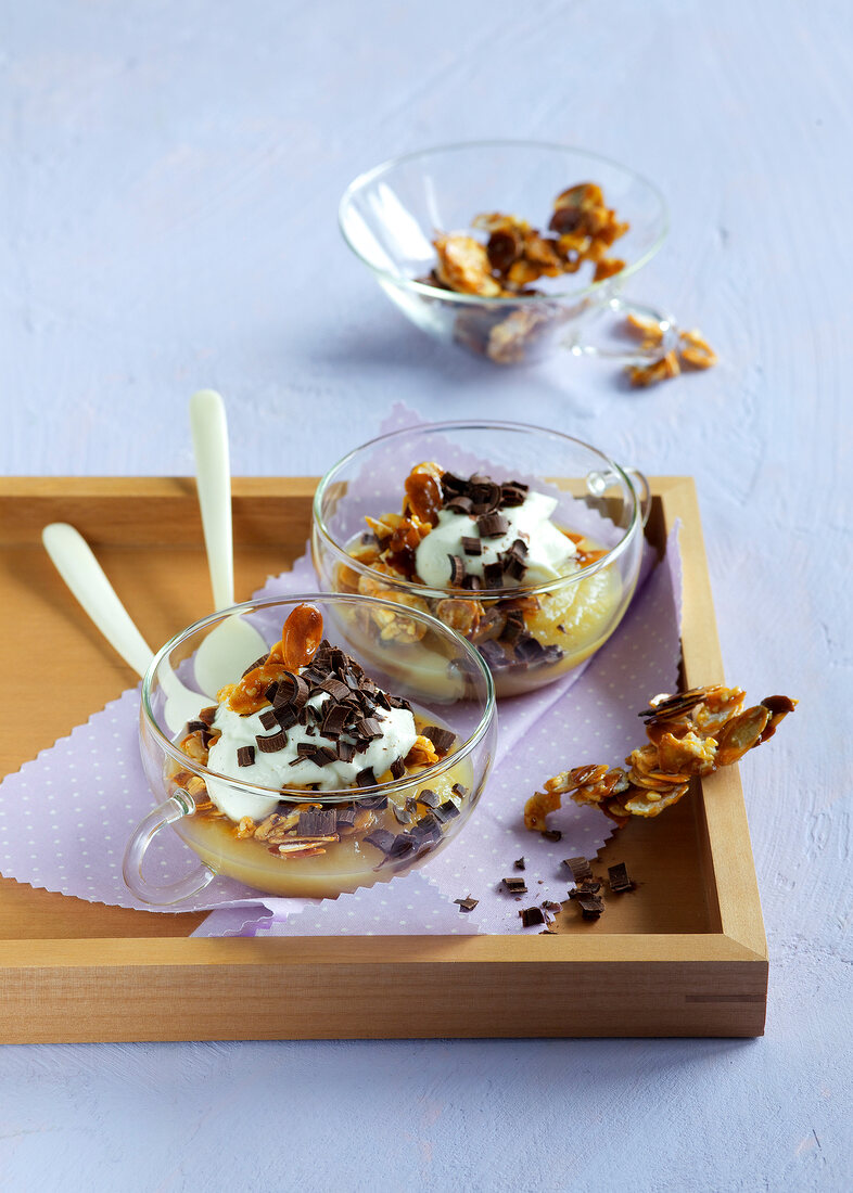 Apple dream with caramel almonds in glass bowl on wooden tray