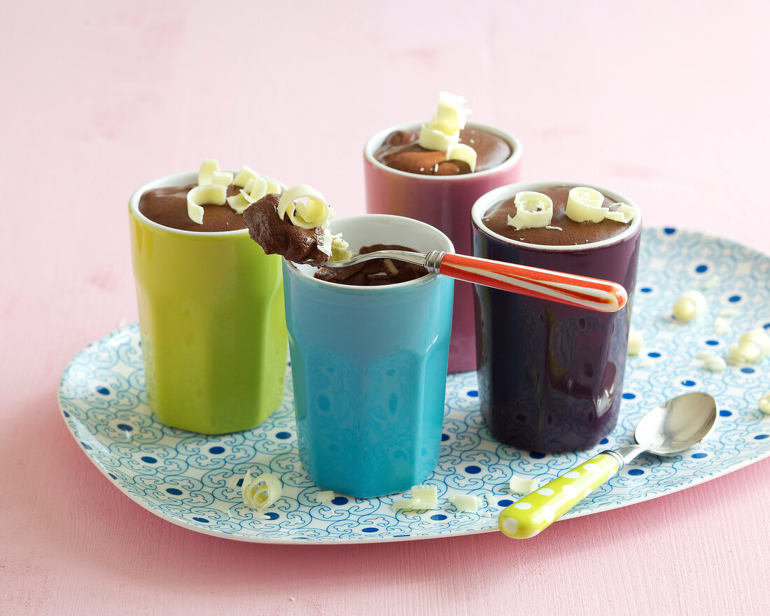 Chocolate mousse in colourful cups on plate