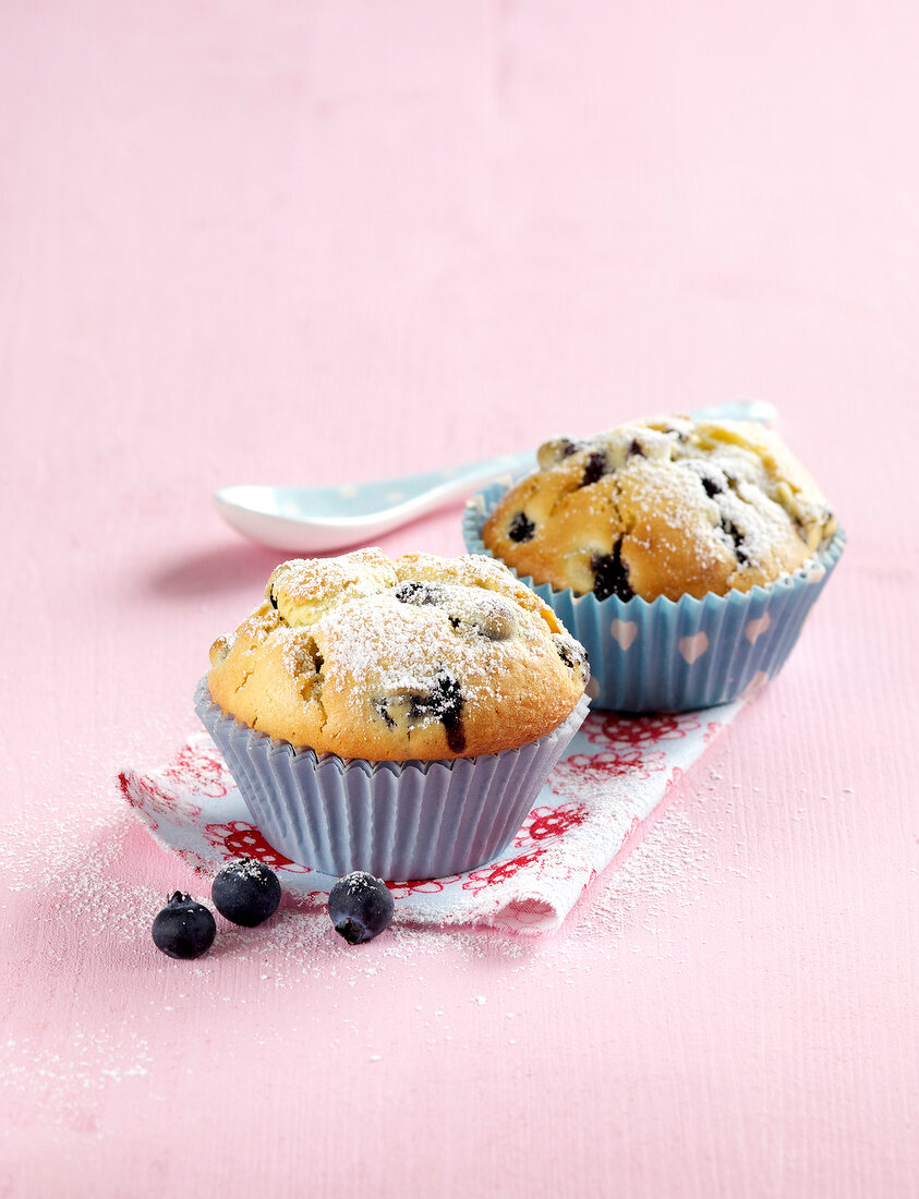 Blueberry muffins on napkin on pink background