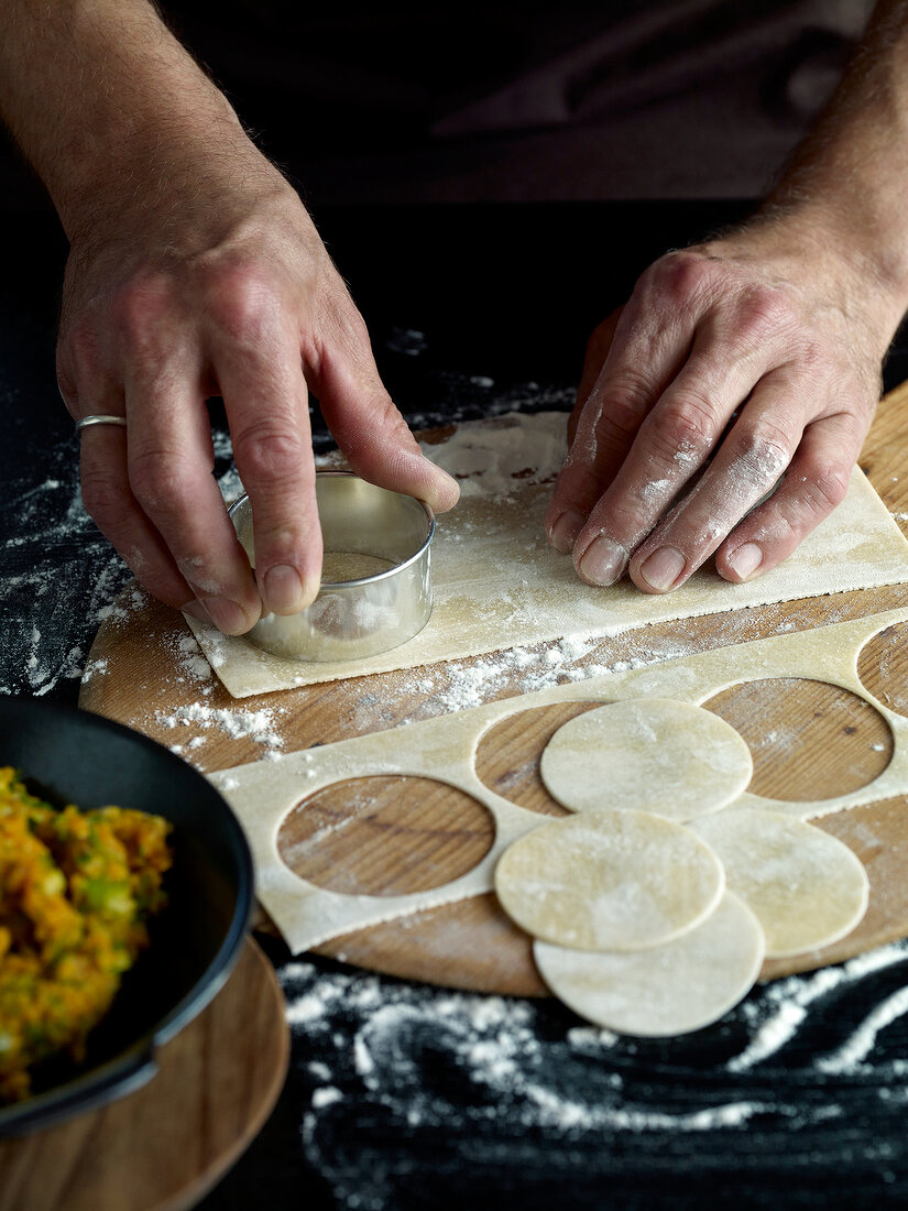 Close-up of dough being cut with pasta cutter for preparation of ravioli pasta, step 2