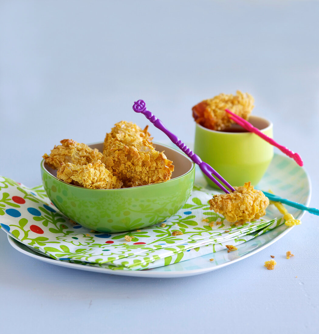 Chicken nuggets in bowl with colourful forks