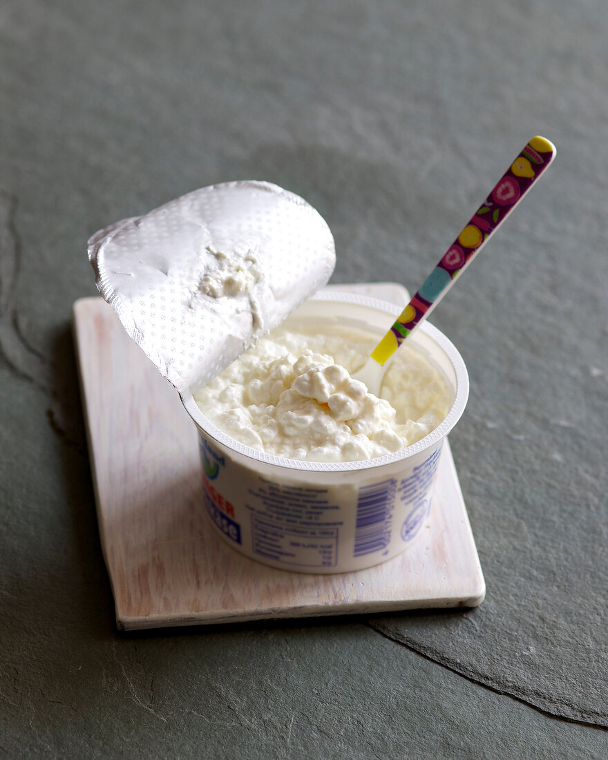 Cottage cheese in plastic container with spoon